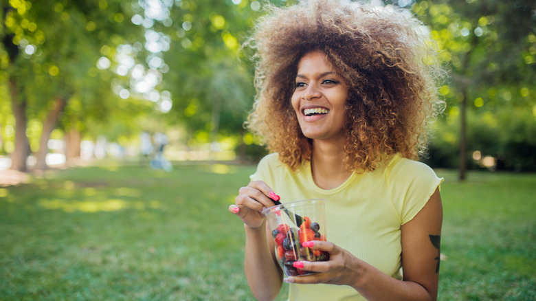 woman in park eating fruit
