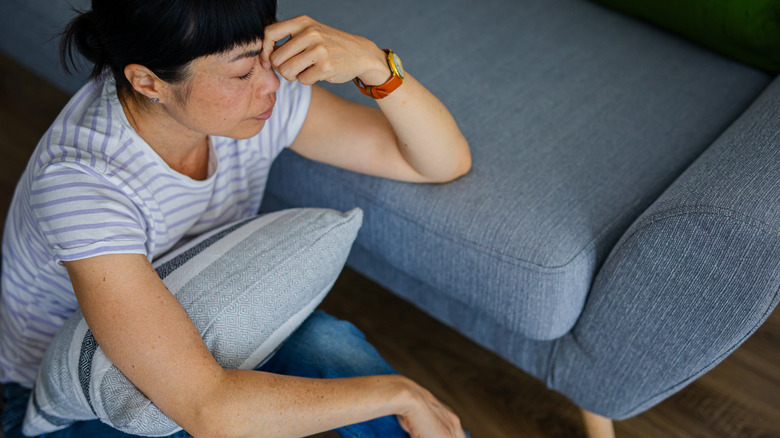 Woman sitting on the floor suffering