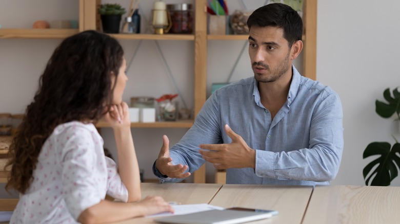 Two people speaking at table