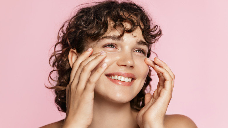 girl smiling while doing her skincare routine