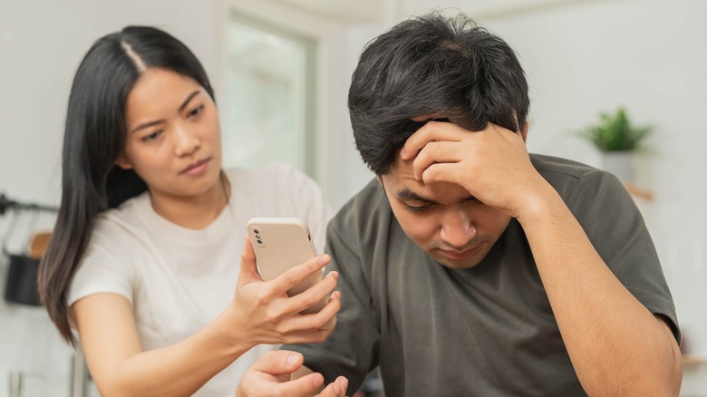 woman with phone confronting man