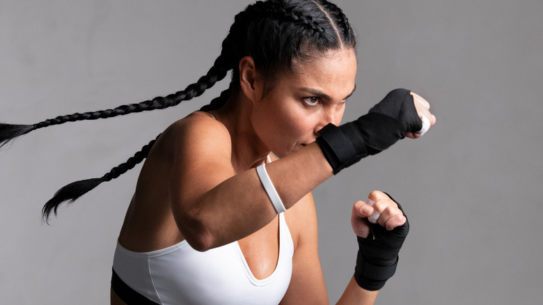 Determined Latinx woman boxing