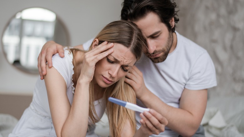 Man comforts woman over negative pregnancy test