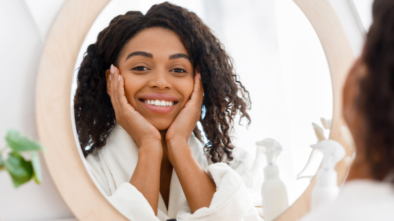 woman happily looking in mirror