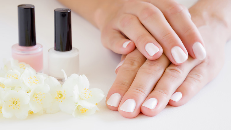 woman's hands with white manicure