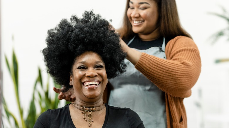 two smiling Black women in hair salon