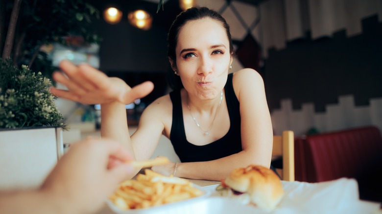 Woman holds up hand at dinner date