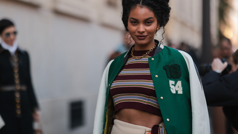 woman wearing green varsity jacket