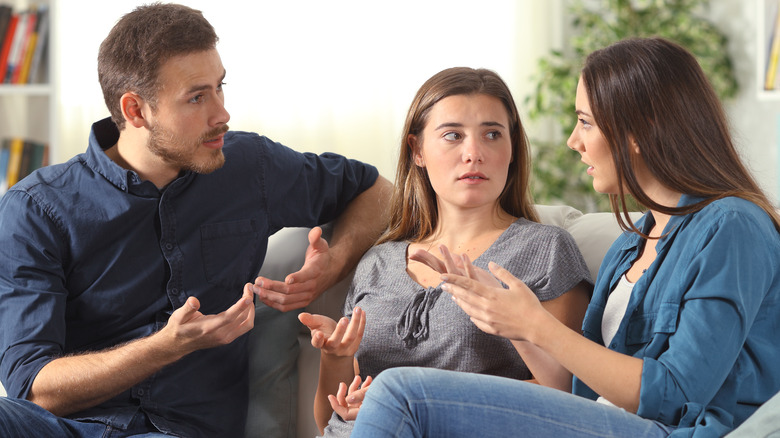 three people talking on couch