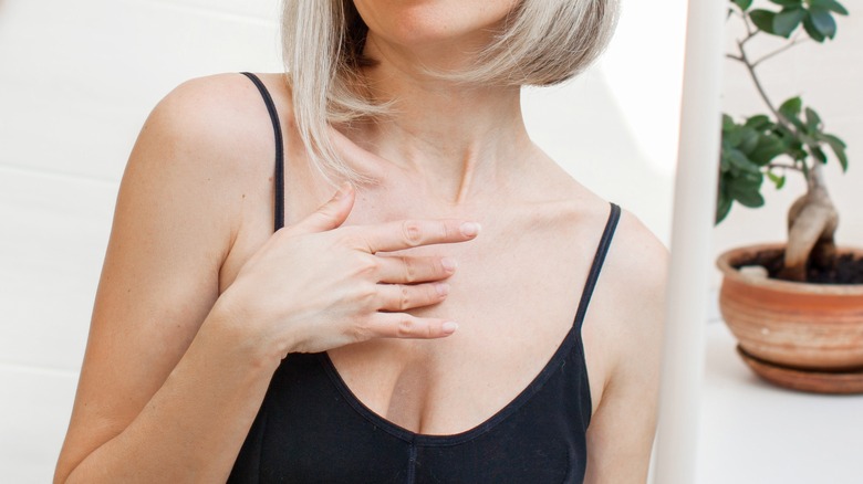 Woman's fingers scratching her chest