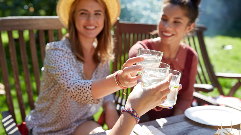 women clinking water glasses