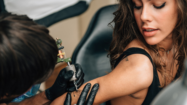 Woman getting tattoo on arm
