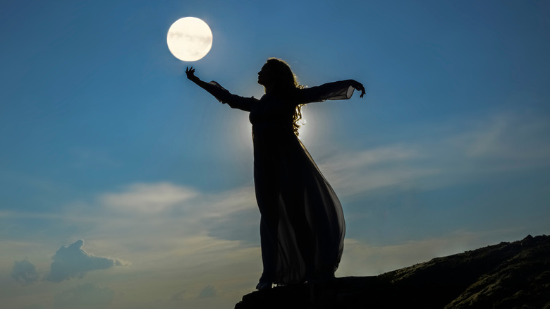 Woman standing under a full moon