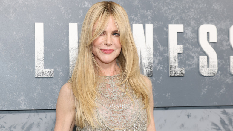 Nicole Kidman posing at event in a lacy dress with long curtain bangs.