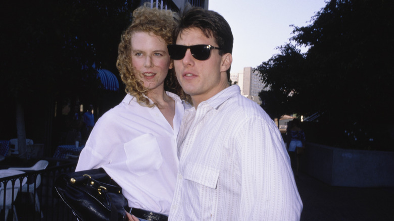 Nicole Kimdan posing with Tom Cruise in 1990 both wearing white button-up shirts.