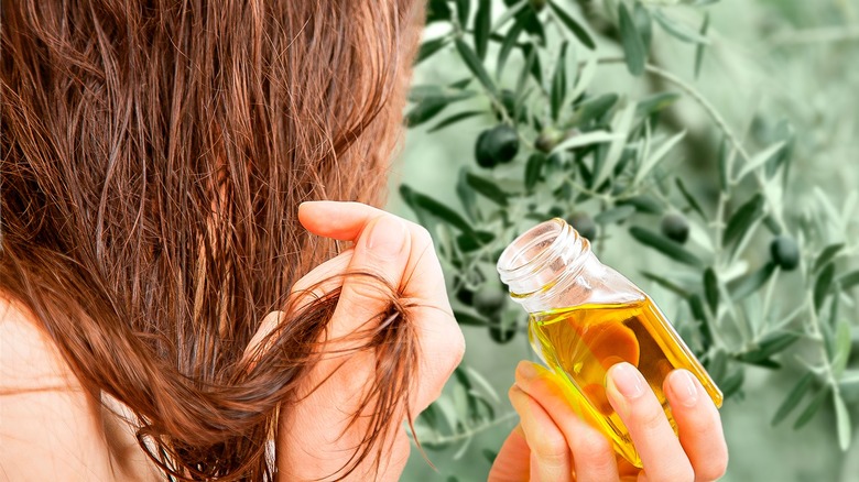 Woman applying olive oil to hair