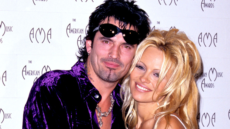 Tommy Lee and Pamela Anderson cuddling at an event.