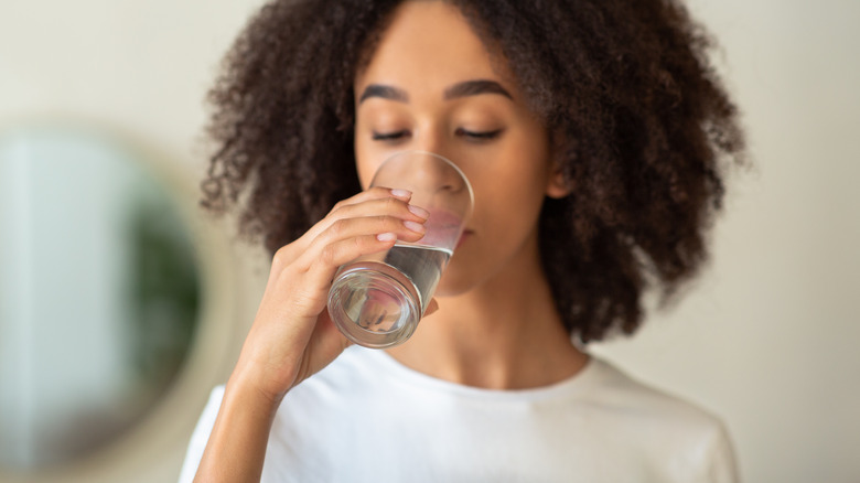 woman drinking out of a glass