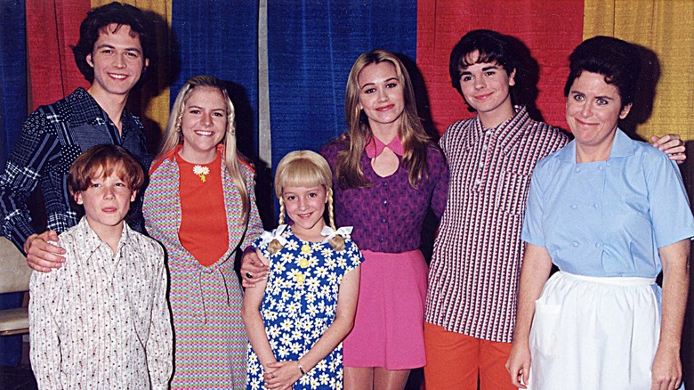 The Brady Bunch movie cast posing together in their costumes.