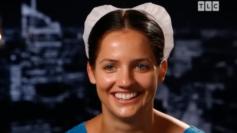 Kate Stoltz smiles wearing a white bonnet