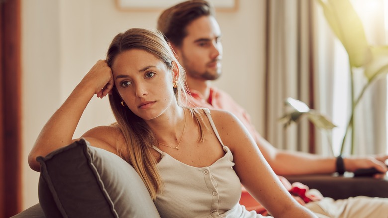 Annoyed woman sits near man