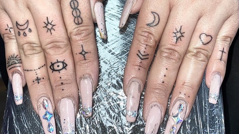 Hands with many finger tattoos 