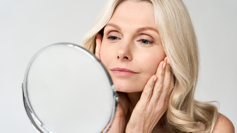 Woman looking at skin in a mirror