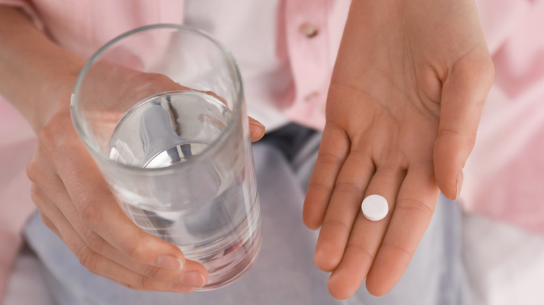 woman with pill and water
