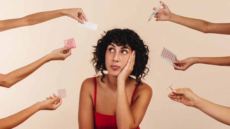 woman surrounded by birth control options