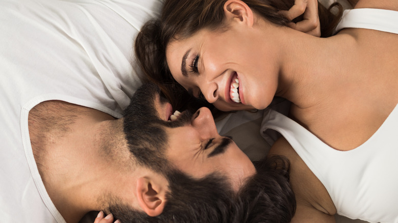 couple in bed laughing