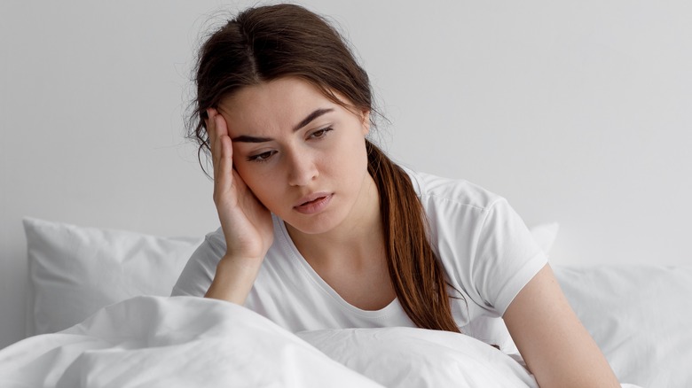 Worried young woman in bed