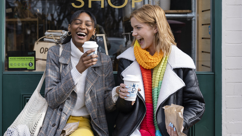 Laughing friends outside shop