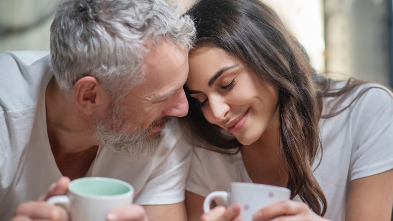 man and woman holding mugs