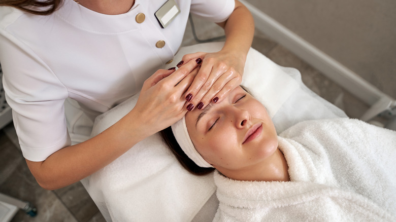 Woman receiving facial treatment