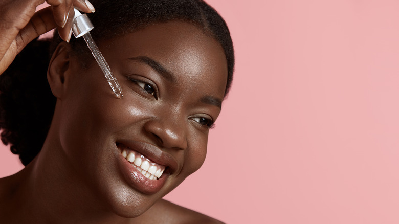 woman adding serum to face