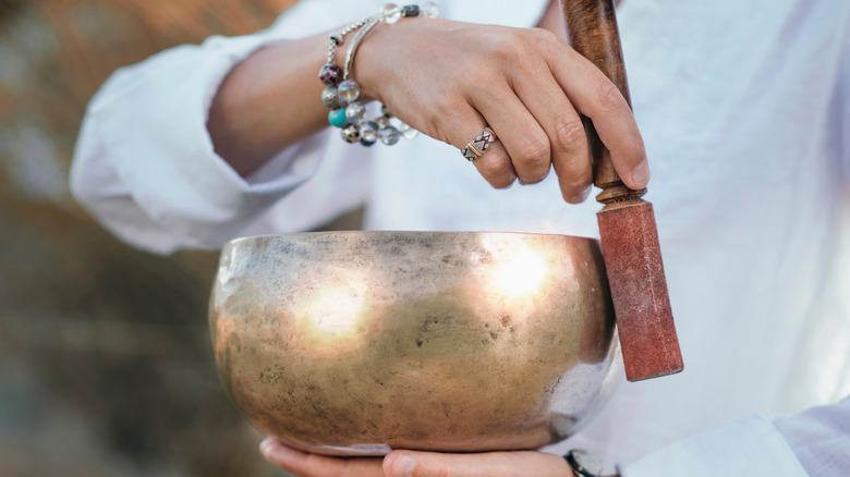 Hands playing Tibetan singing bowl