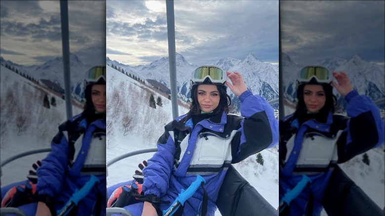 Individual in snowsuit with purple and white colorblocking