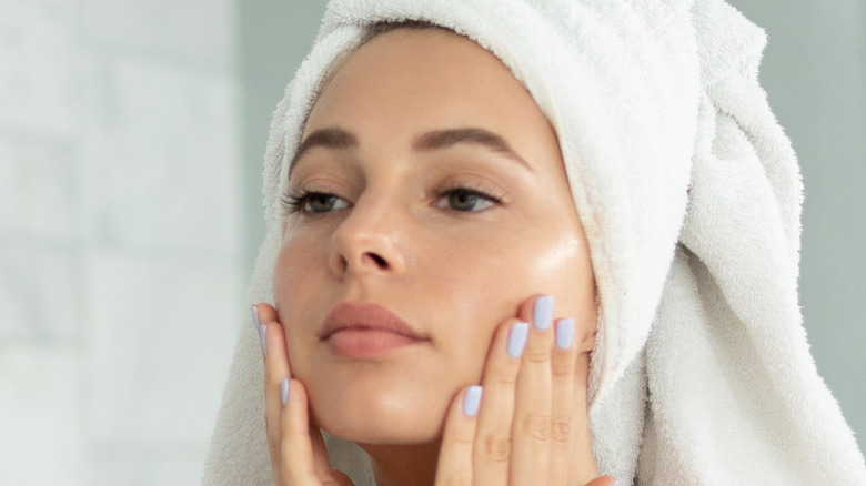 A woman applying face cream 