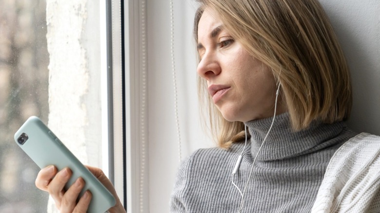 Blond woman frowning at phone