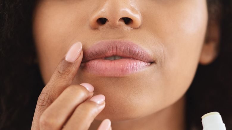 woman applying lip balm
