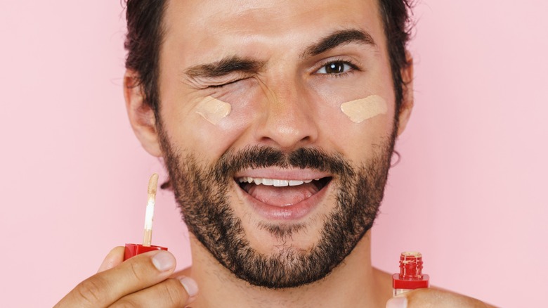 Man applying concealer 