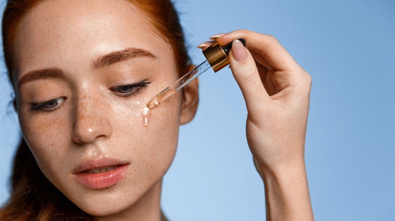 woman applying serum with dropper