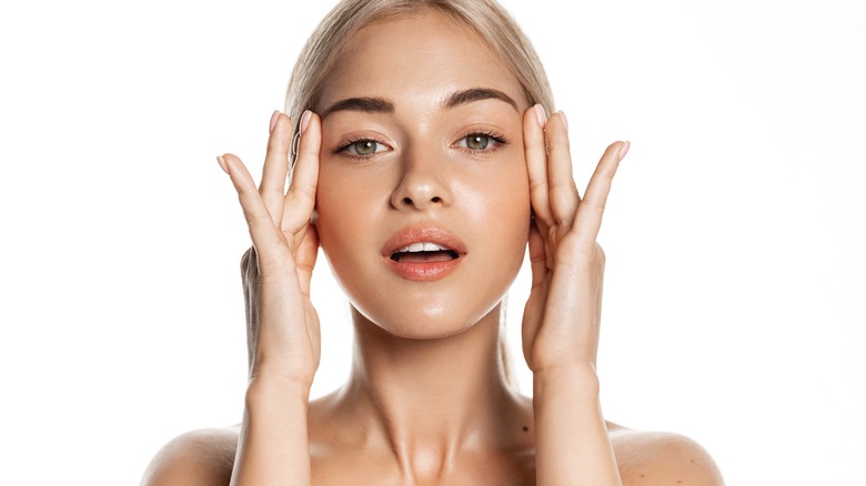 woman applying serum on face