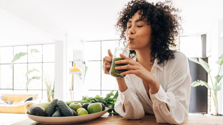 Woman drinks green juice