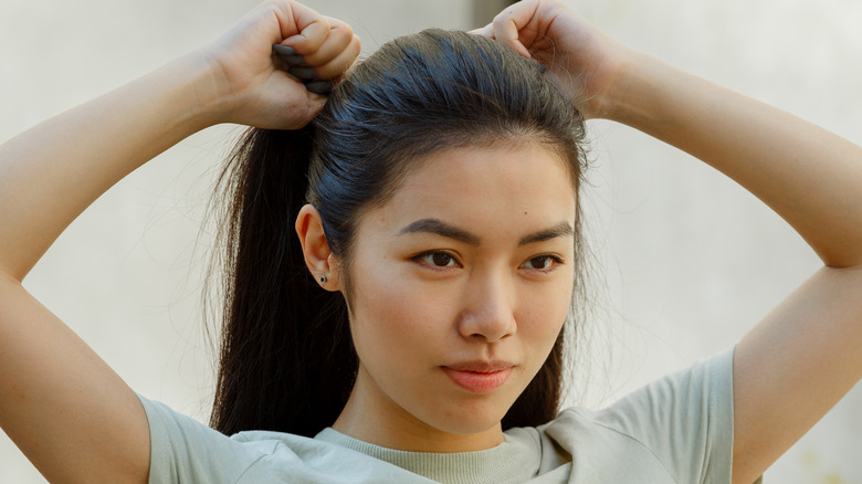 woman pulling back her hair