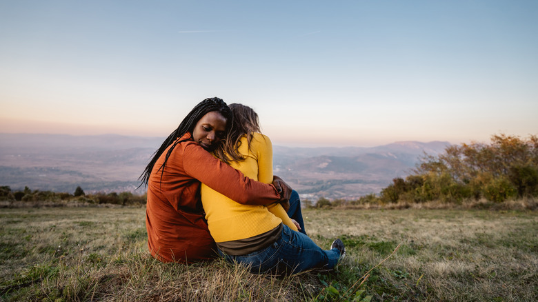 friends hugging in meadow