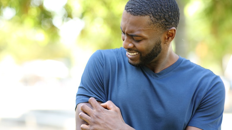 Man itches heat rash on arm 