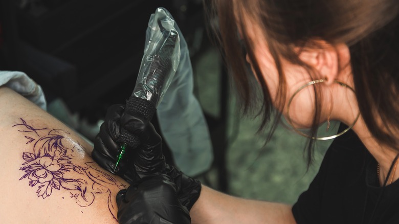 Artist applying tattoo in studio
