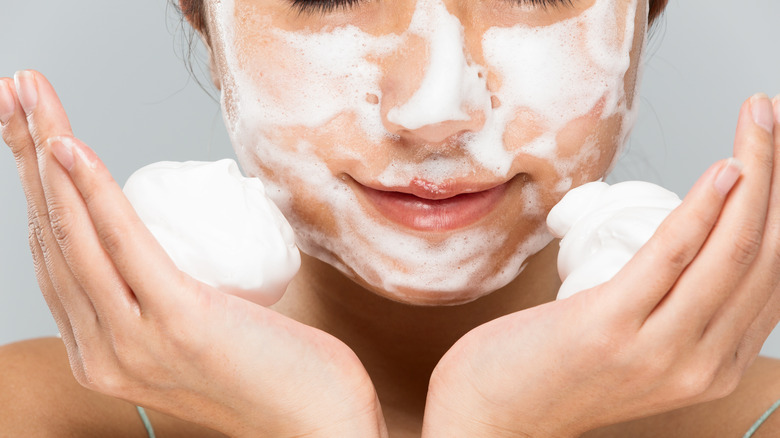 woman washing face with lots of foam