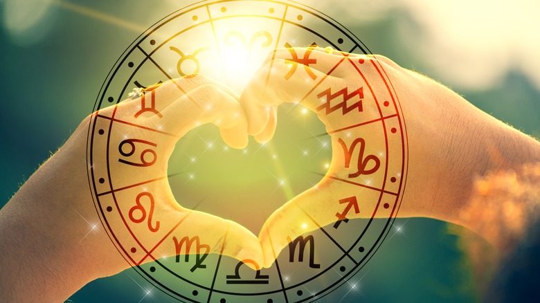 Heart hands behind an Astrology circle chart